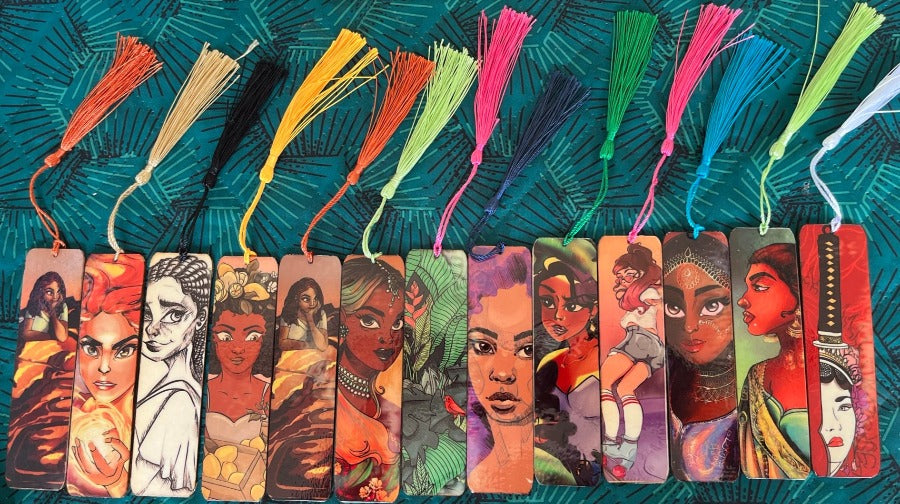 Le marque page est sublimé par une illustration sur une face. Le logo et le nom sont de l'autre côté. un petit pompon coloré décore le tout.